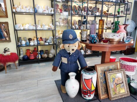 Teddy, Vasen, Bilder im Vordergrund, dahinter Regale mit Porzellan und Schmuck