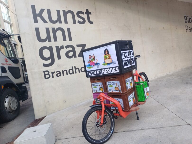 Rotes Lastenrad von CycleHeroes mit Adamah Biokisten geladen.