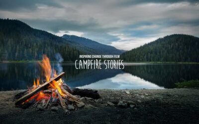 Lagerfeuer, See, dahinter bewaldete Hügel; Text: Campfire stories - inspiring change through film